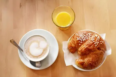 a table with a cup of coffee and two pastries at Grammy Suite in Rome