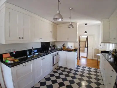 a kitchen with white cabinets and a checkered floor at Luce, Silenzio ed Eleganza nel Cuore di Roma - 2 camere da letto in Rome