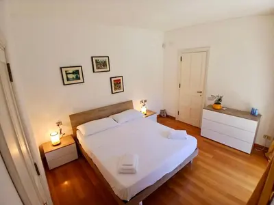 a bedroom with a large white bed and two lamps at Luce, Silenzio ed Eleganza nel Cuore di Roma - 2 camere da letto in Rome