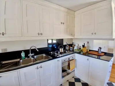 a kitchen with white cabinets and a sink at Luce, Silenzio ed Eleganza nel Cuore di Roma - 2 camere da letto in Rome