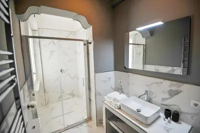 a bathroom with a shower and a sink and a mirror at Boutique Suites Valadier in Rome