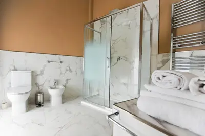 a bathroom with a toilet and a glass shower at Boutique Suites Valadier in Rome