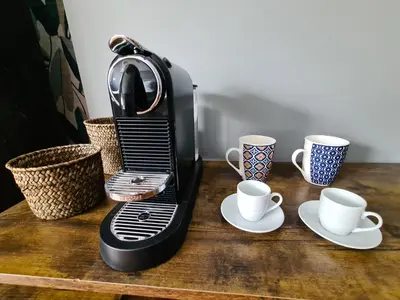 a coffee maker sitting on a wooden table with two cups at Boutique Suites Valadier in Rome