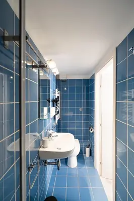 a blue tiled bathroom with a sink and a mirror at Barletta Vatican Rooms in Rome