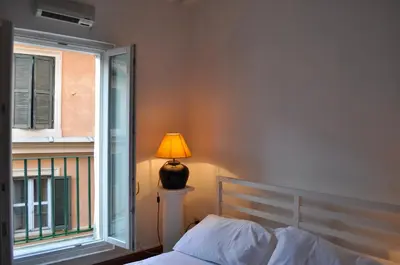 a bedroom with a bed and a lamp next to a window at Pantheon Suite in Rome