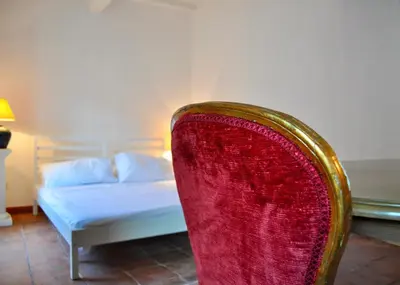 a bedroom with a bed and a red chair at Pantheon Suite in Rome