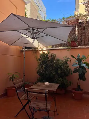 a table and chair under an umbrella on a patio at Cortile San Tommaso in Rome