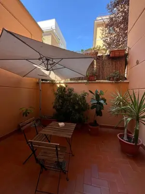 a patio with an umbrella and a table and chairs at Cortile San Tommaso in Rome