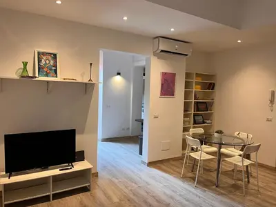 a living room with a table and a television at Cortile San Tommaso in Rome