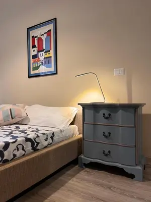 a bedroom with a bed and a dresser with a lamp at Cortile San Tommaso in Rome