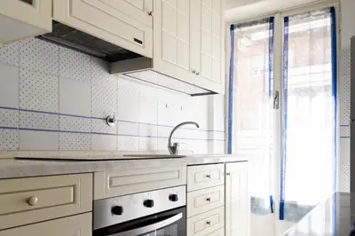 a kitchen with white cabinets and a sink and a window at Appartamento Scena Vaticana in Rome