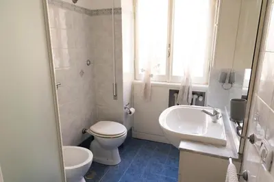 a white bathroom with a toilet and a sink at Appartamento Scena Vaticana in Rome
