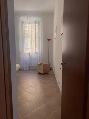 a hallway with a room with a dresser and a window at Rione Testaccio Apartment in Rome