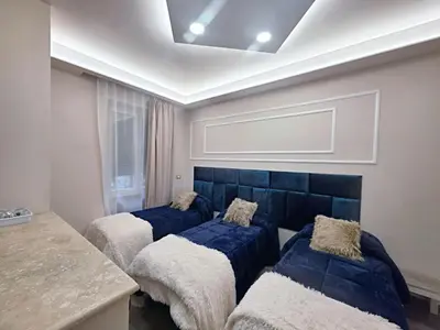 three beds in a room with a blue headboard at Glint House Prestige in Rome