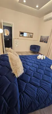 a large blue bed with a blue comforter in a room at Glint House Prestige in Rome
