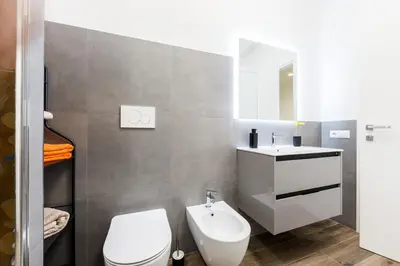 a bathroom with a white toilet and a sink at Maison Chic Cornelia - San Pietro in Rome