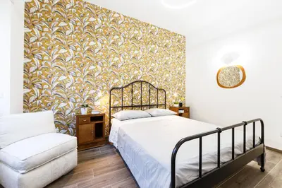 a bedroom with a bed and a wall mural at Maison Chic Cornelia - San Pietro in Rome