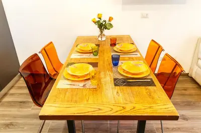 a wooden table with yellow dishes on it at Maison Chic Cornelia - San Pietro in Rome