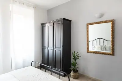 a bedroom with a black cabinet and a mirror at Loving Testaccio in Rome