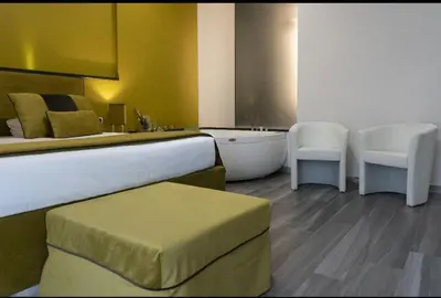 a bedroom with a bed and two chairs and a tub at Le Stanze di Elisa in Rome