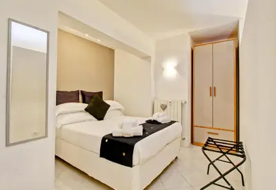 a bedroom with a white bed and a mirror at Fermata San Pietro - appartamento con parcheggio in Rome