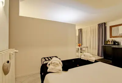 a hotel room with a bed with towels on it at Fermata San Pietro - appartamento con parcheggio in Rome