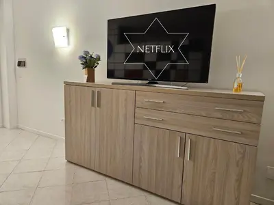 a tv on top of a wooden entertainment center at Fermata San Pietro - appartamento con parcheggio in Rome