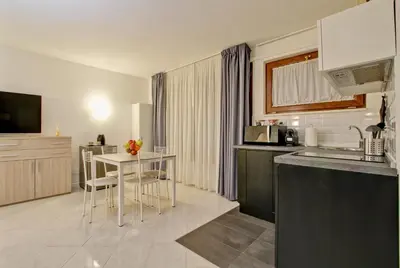 a kitchen with a table and a small table with chairs at Fermata San Pietro - appartamento con parcheggio in Rome