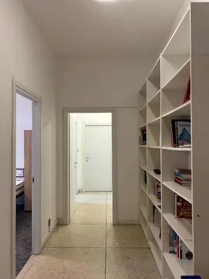 a hallway with white shelves and a door to a room at San Pietro - Musei Vaticani Appartamento spazioso in Rome