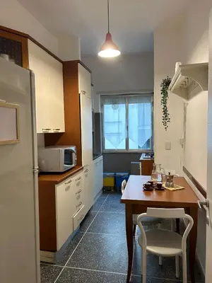 a kitchen with a table and a kitchen with a refrigerator at San Pietro - Musei Vaticani Appartamento spazioso in Rome