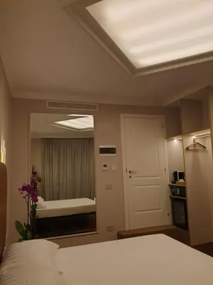 a bedroom with a white bed and a large mirror at Appian Private Suites in Rome