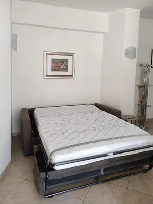 a bed in a room with a white wall at Oasi Ridolfi in Rome
