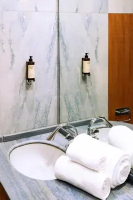 a bathroom with a sink and a mirror and towels at Arancio Luxury Accomodation in Rome