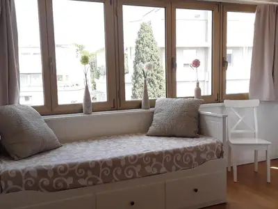 a room with a window with a bed and a chair at L'Attico di San Saba in Rome