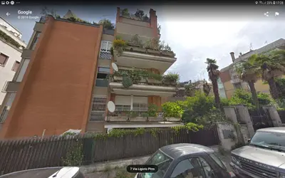 a building with a fence and cars parked in front of it at L'Attico di San Saba in Rome