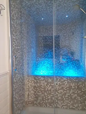 a bathroom with a shower with blue lights in it at L'Attico di San Saba in Rome