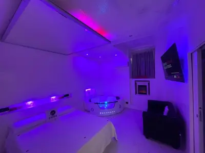 a purple room with a bath tub and a table at Moya Suites 2 - SPA in Camera in Rome