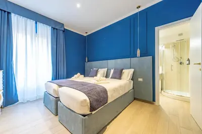 a bedroom with a large bed with blue walls at Catone Vatican Suites by Ghor in Rome