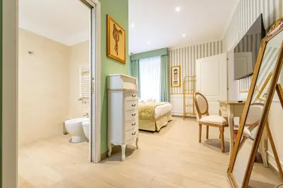 a bedroom with a bed and a desk and a bathroom at Catone Vatican Suites by Ghor in Rome