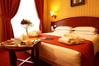 a hotel room with a bed with a tray of food on it at Augusta Lucilla Palace in Rome