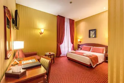 a hotel room with a bed and a desk at Augusta Lucilla Palace in Rome