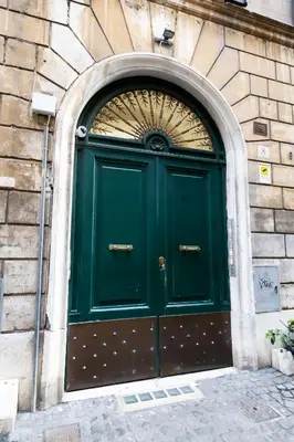 a green door on the side of a building at Sweet Navona Duplex Apartment in Rome