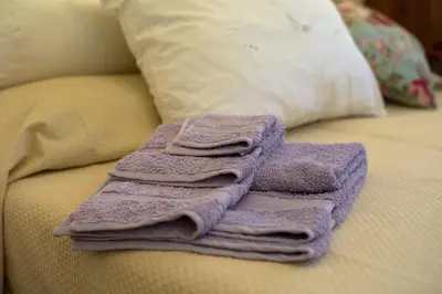 a pile of purple towels sitting on top of a bed at Gianicolo Penny's Garden a Roma centro in Rome