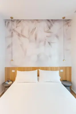 a bedroom with a white bed and a white wall at Caesar Boutique Apartment in Rome