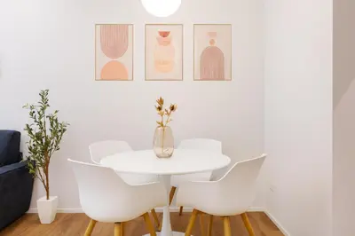 a white dining room with a white table and chairs at Caesar Boutique Apartment in Rome