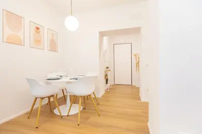 a white dining room with a white table and white chairs at Caesar Boutique Apartment in Rome