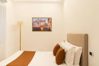 a bedroom with a white bed with a picture on the wall at Bonsignore Luxury Accomodation in Rome
