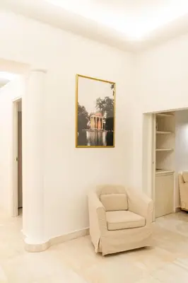 a living room with a chair and a picture on the wall at Bonsignore Luxury Accomodation in Rome