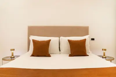 a white bed with four pillows and two lamps at Bonsignore Luxury Accomodation in Rome