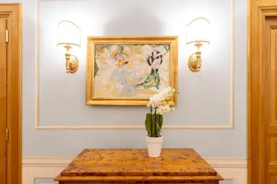 a vase of flowers on a table with two lights at Pantheon Suites in Rome in Rome